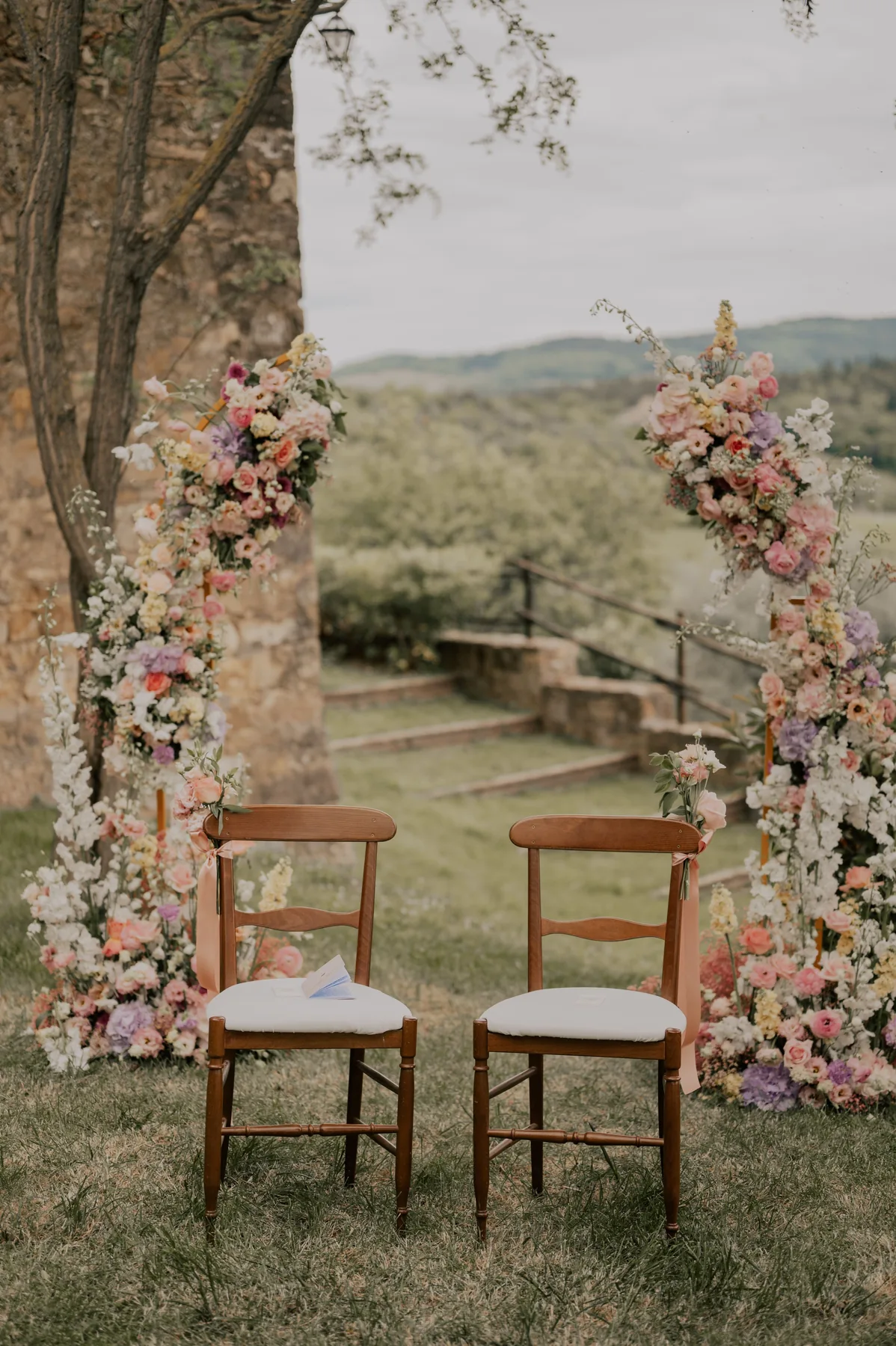 Arche florale et deux chaises installées face au paysage, cérémonie de mariage