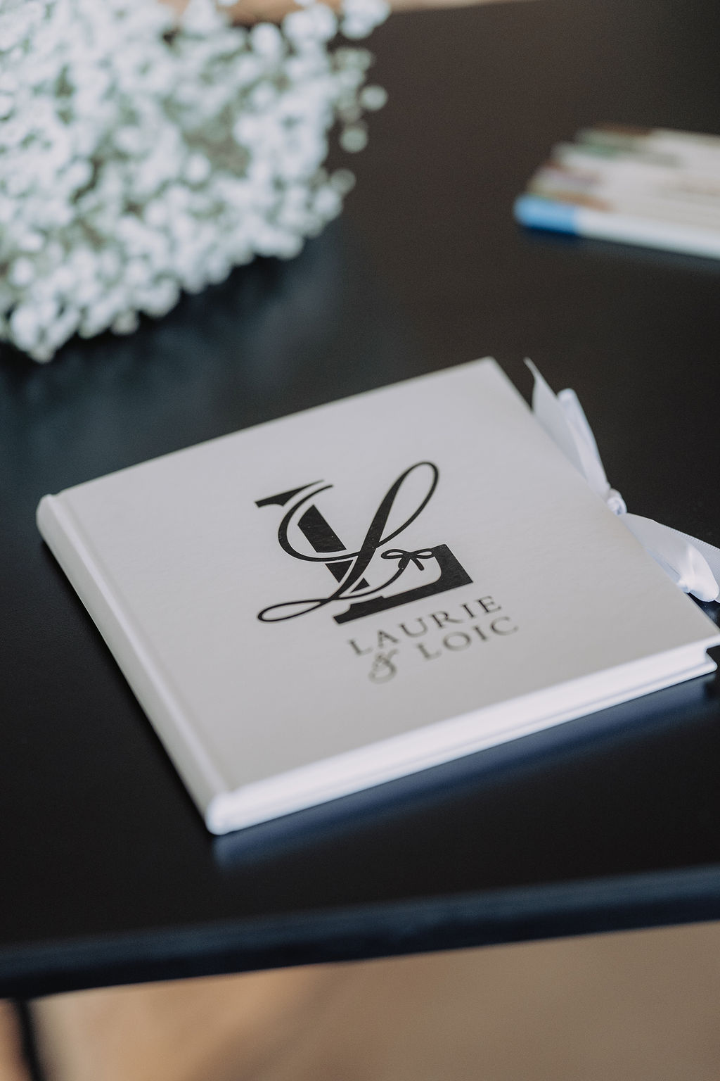 Livre d'or au monogramme, mariage blanc et noir décoré par Mona Ilsa, décoratrice de mariage