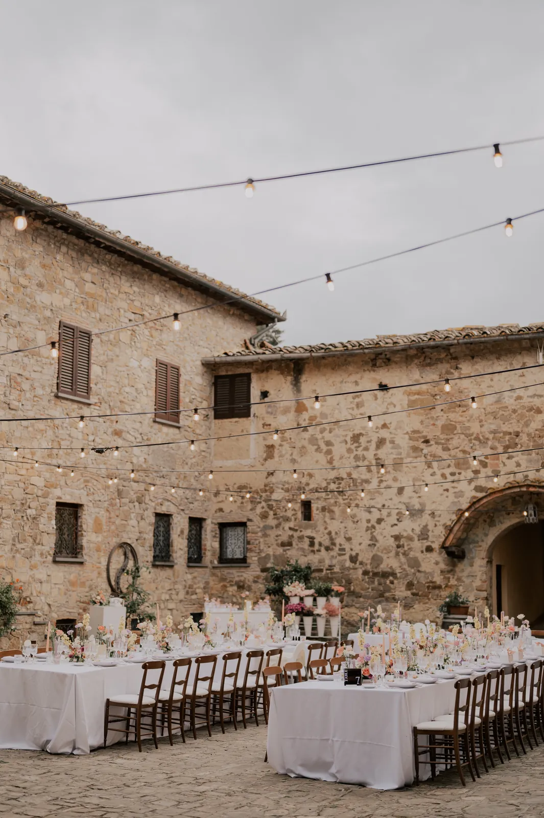 Tablées dans la cour en pierre, mariage en italie décoré par Mona Ilsa, décoratrice de mariage