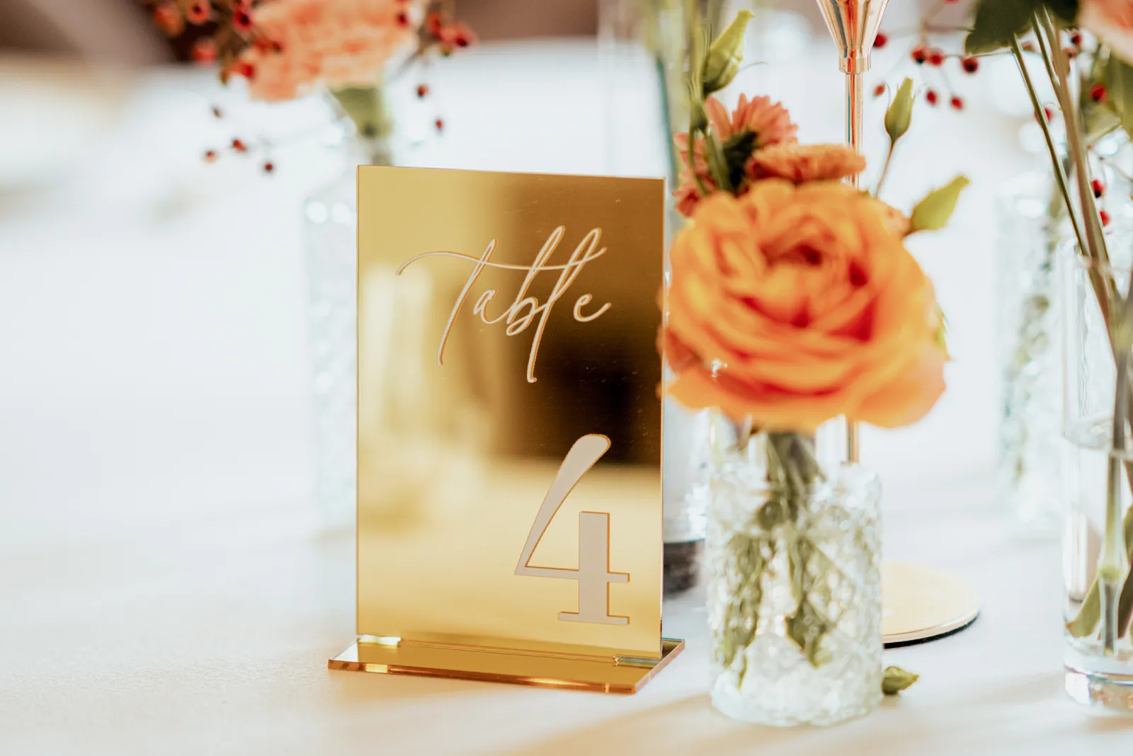 Numéro de table doré, mariage orangé décoré par Mona Ilsa, décoratrice de mariage