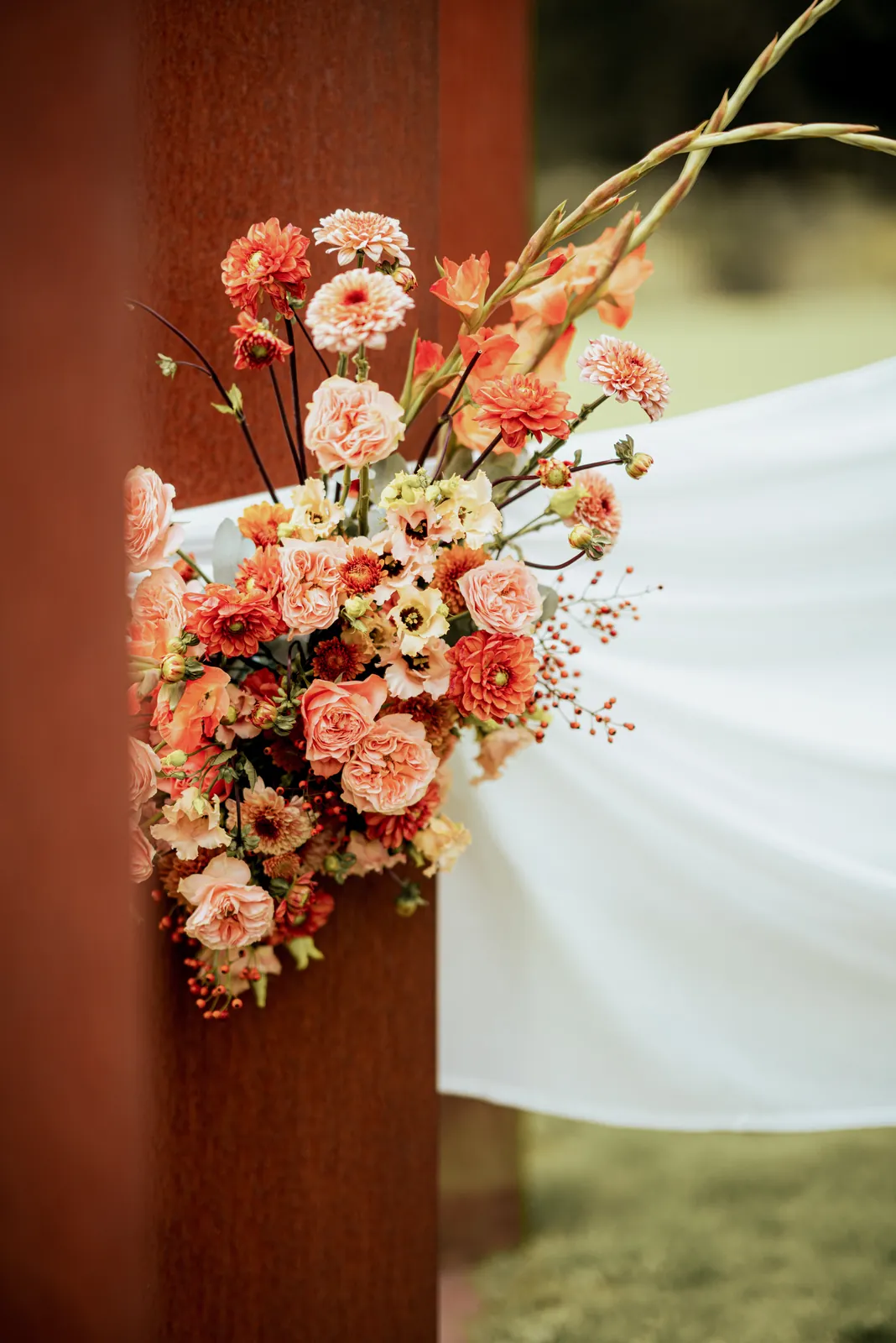 Poteau fleuri, mariage orangé décoré par Mona Ilsa, décoratrice de mariage