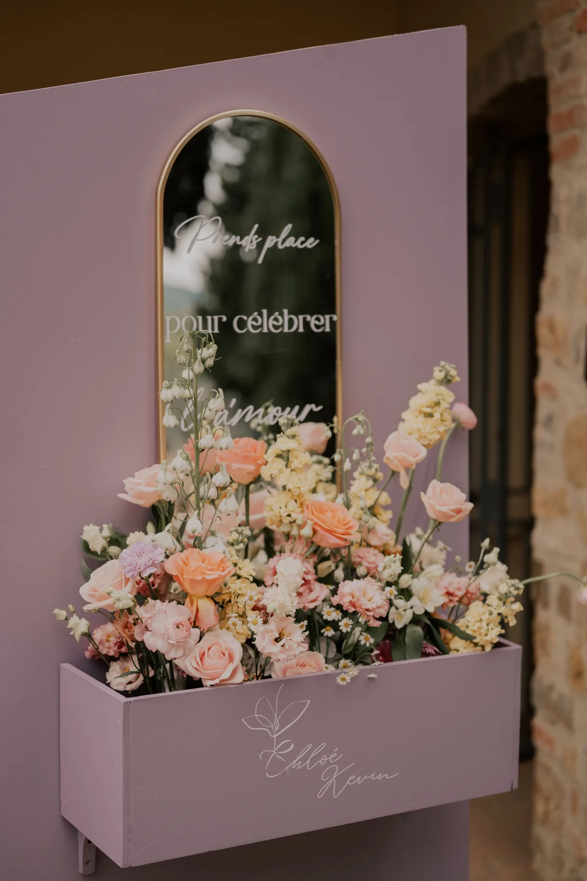 Panneau d'accueil rose poudré, miroir doré et jardinière fleurie