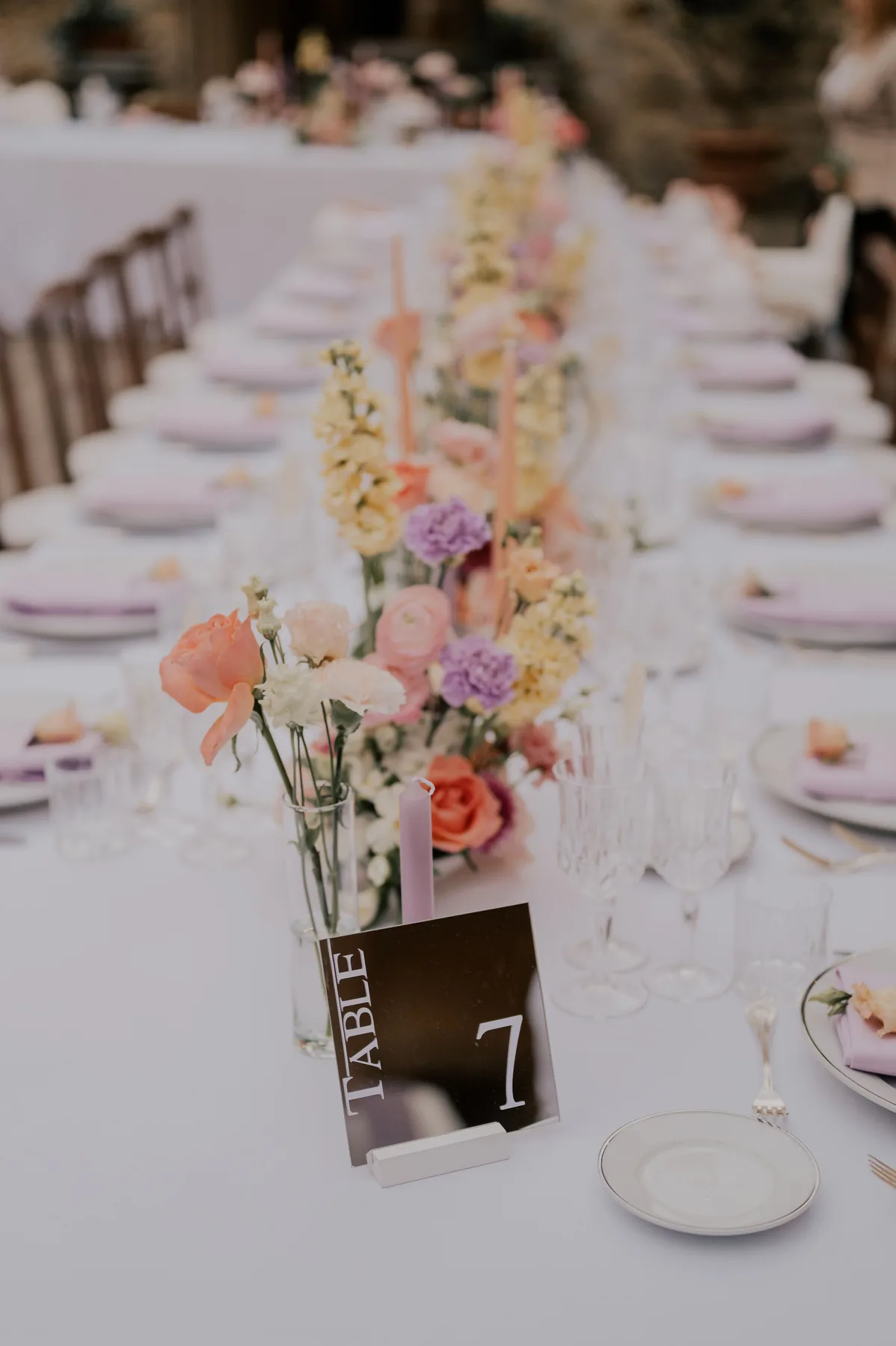 Table de banquet dressée, fleurs pastel et marque-table, décoration de mariage