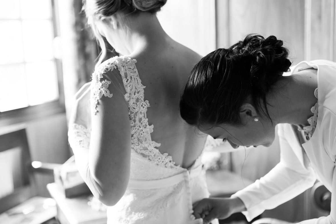 Les derniers laçages de la robe de la mariée, en noir et blanc