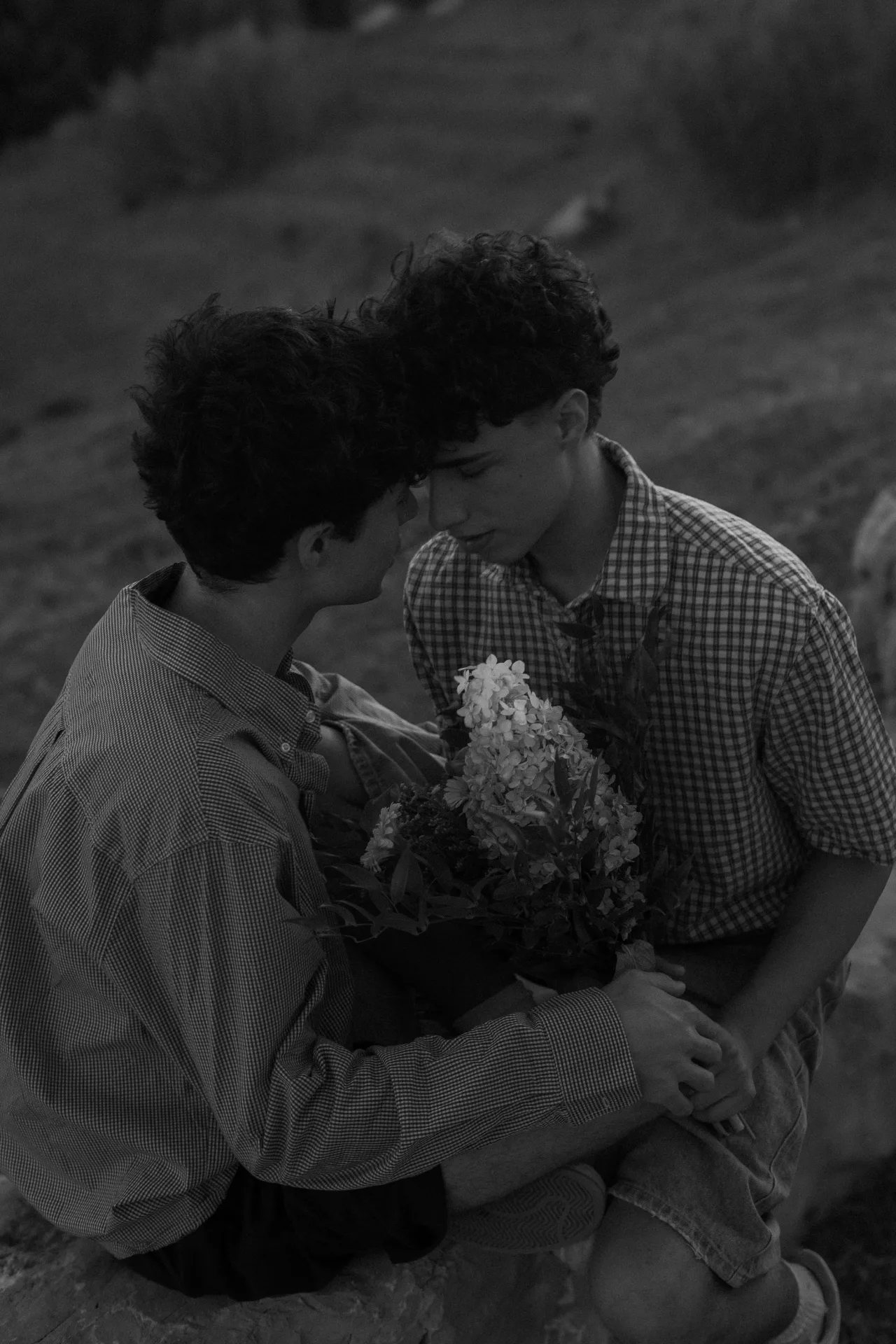 Portrait en noir et blanc d'un couple tenant un bouquet de fleurs