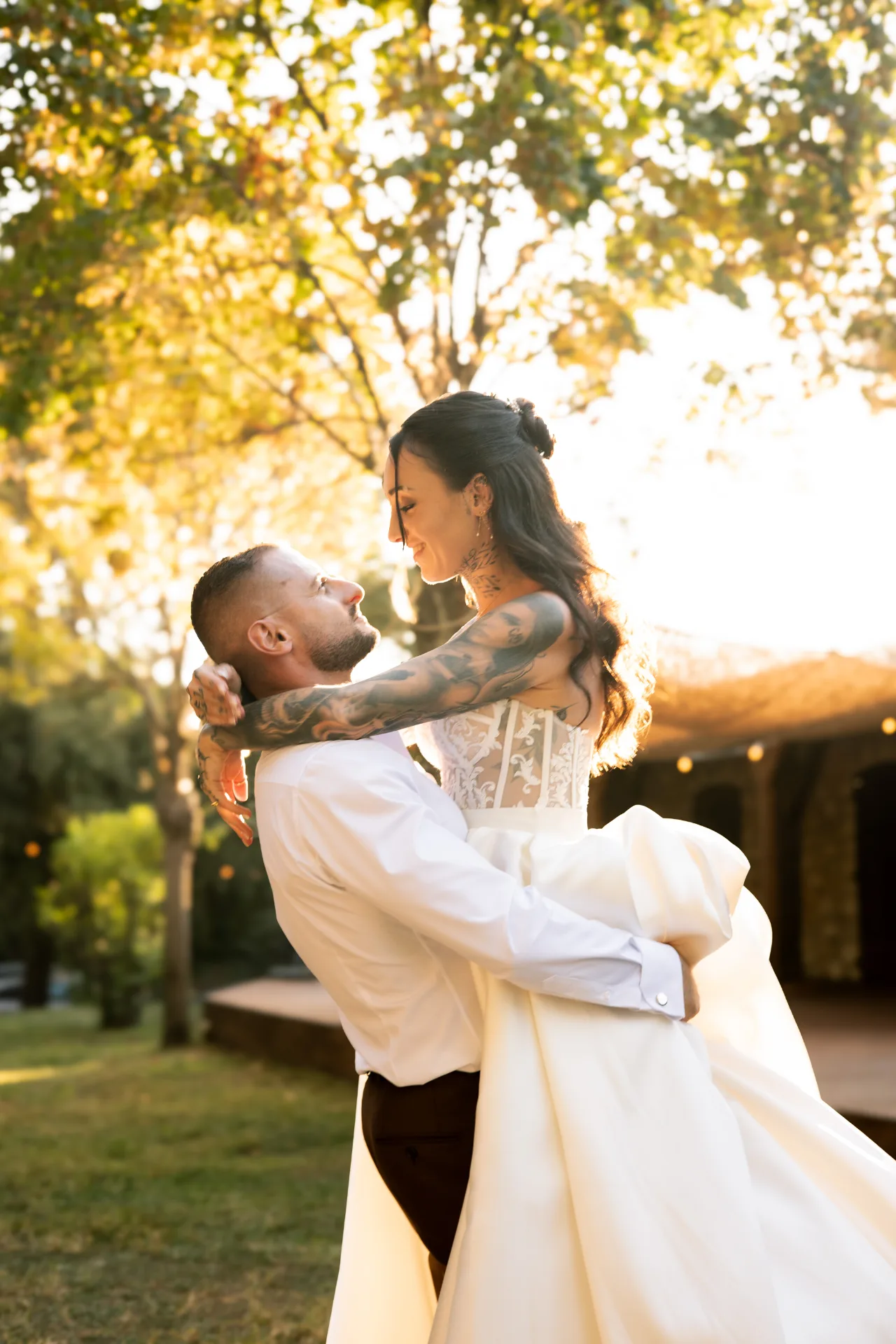 Le marié portant la mariée dans la lumière dorée du soir